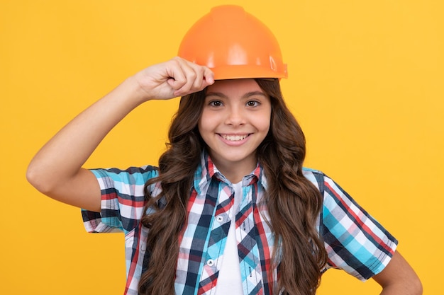 Happy kid with curly hair in construction helmet, architect.