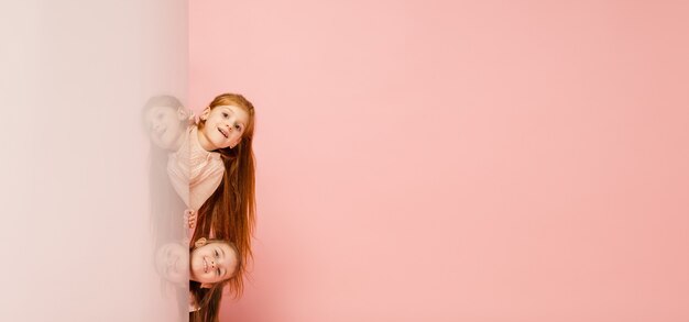Happy kids, girls isolated on coral pink