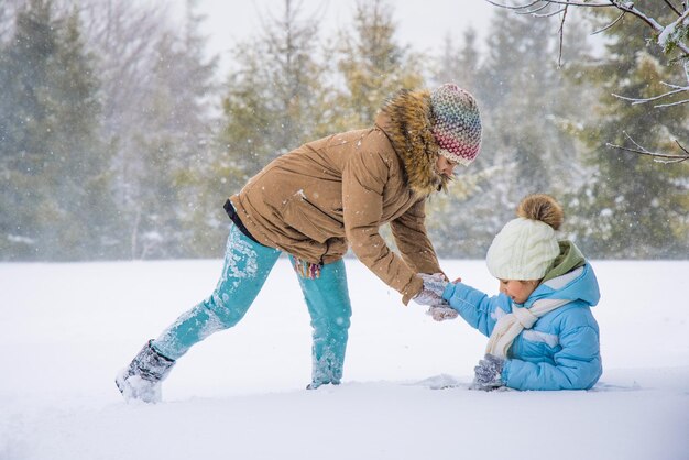 雪に覆われたトウヒの森で走っている幸せな子供たち Premium写真