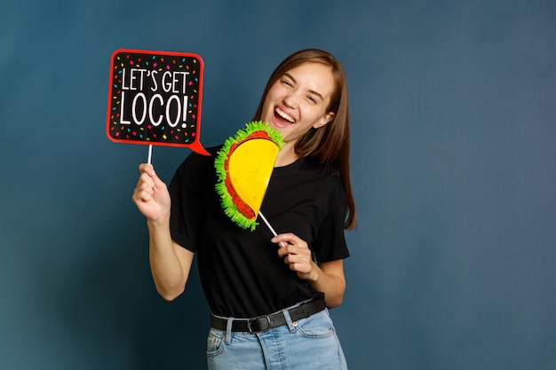 Happy lady holding board and laughing on blue background