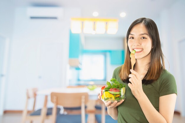 コピースペースの背景の上に台所用品を持って幸せな女