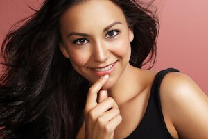 Free photo happy latin woman smiling on a pink background