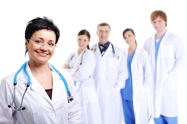 Happy laughing female doctor at foreground and other doctors