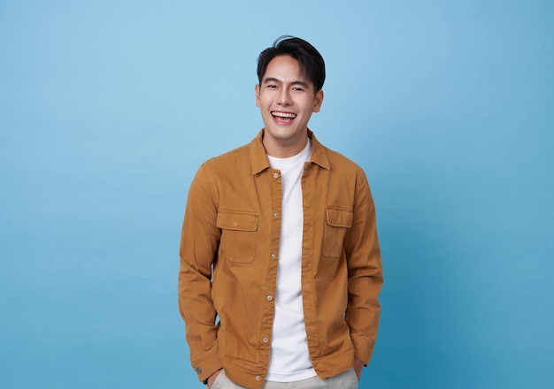 Free photo happy laughing young handsome southeast asian man isolated on blue studio background