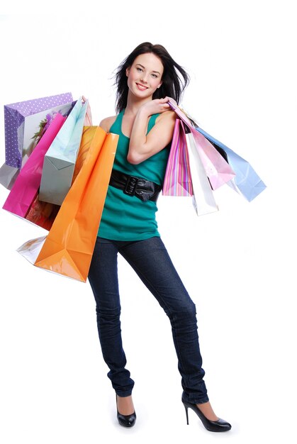 Happy laughing young woman with color bags