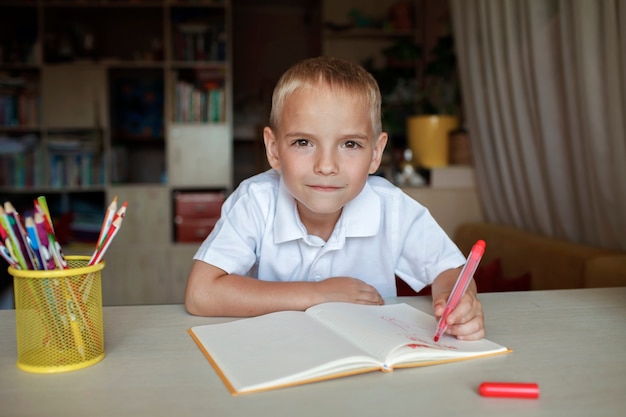 Счастливый левша мальчик пишет в бумажной книге левой рукой международный день левши