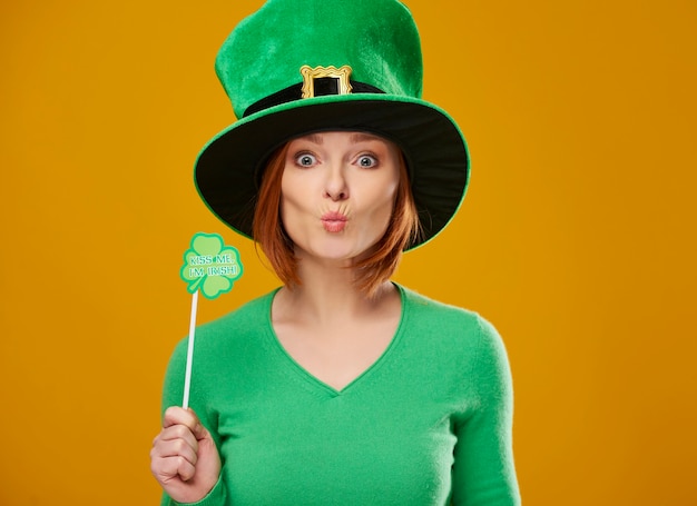 Бесплатное фото Счастливый гном в зеленой шляпе, посылающий воздушный поцелуй