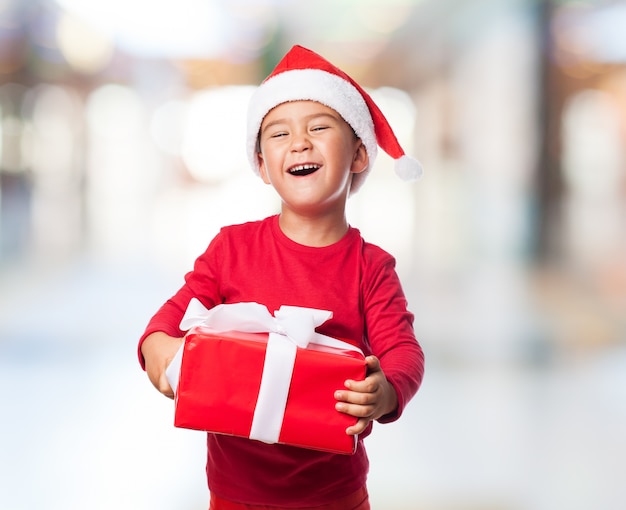 Happy little boy holding a heavy present