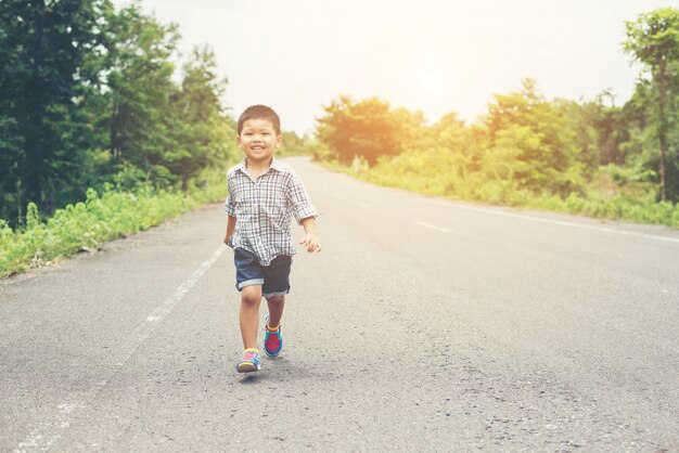 Happy little boy in motion, smiley running on the street.