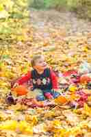 Free photo happy little boy with pumpkin looking away