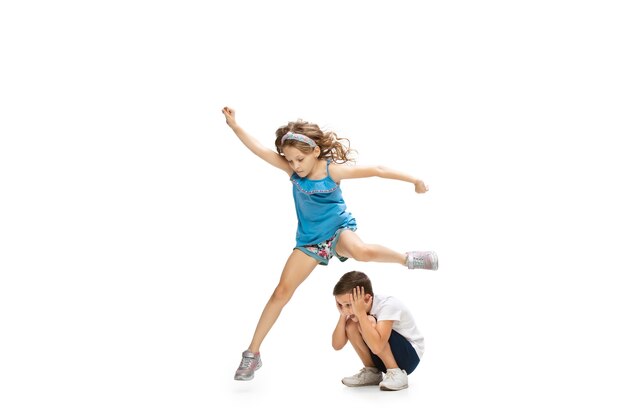 Happy little girl and boy running on white wall