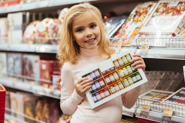 Happy little girl choosing candy