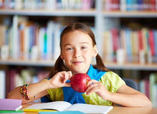 Счастливый маленькая девочка держит яблоко