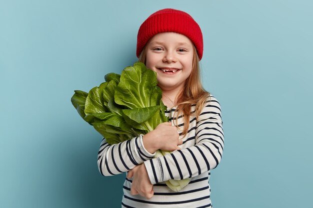 Happy little girl holding salad