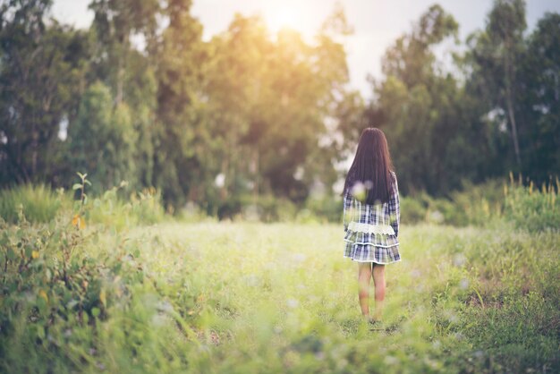 Happy little girl standing in the meadow