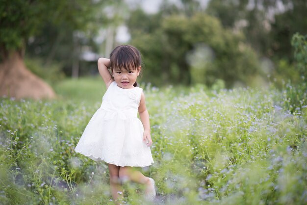 Счастливый маленькая девочка, стоя на лугу