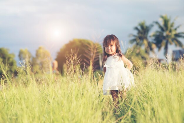 Happy little girl standing in the meadow