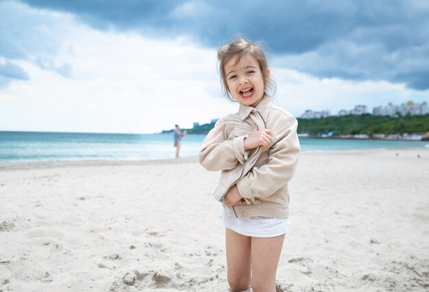 海沿いのビーチで晴れた日に幸せな少女。