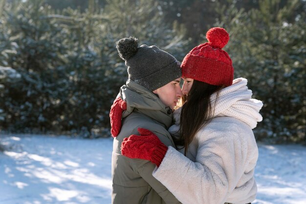 冬​の​森​で​幸せな​恋人たち​の​抱擁​。​外​を​歩く​の​が​大好きな​若い​カップル​。