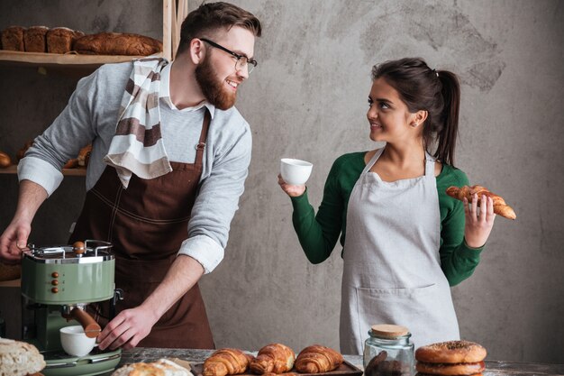 Happy loving couple bakers drinking coffee