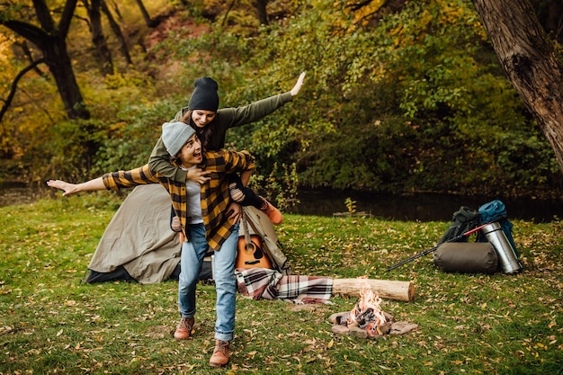 행복한 연인 커플은 텐트 근처의 숲에서 즐거운 시간을 보내고 비행기를 만든다