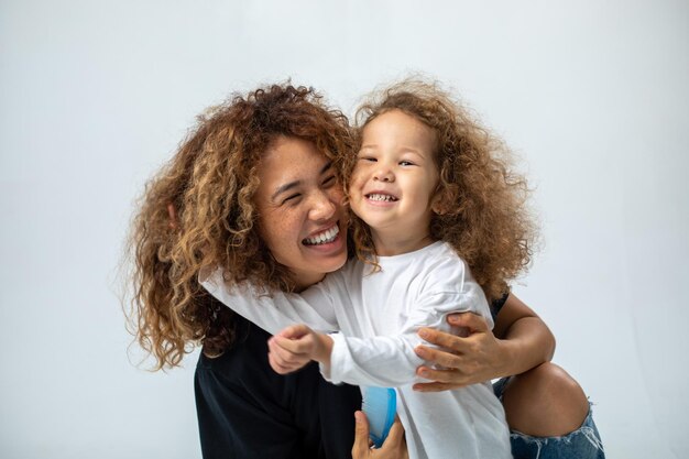 Happy loving family mother and her daughter child girl playing and hugging