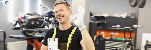 Happy male auto mechanic makes ok gesture in car service recommendations and highquality