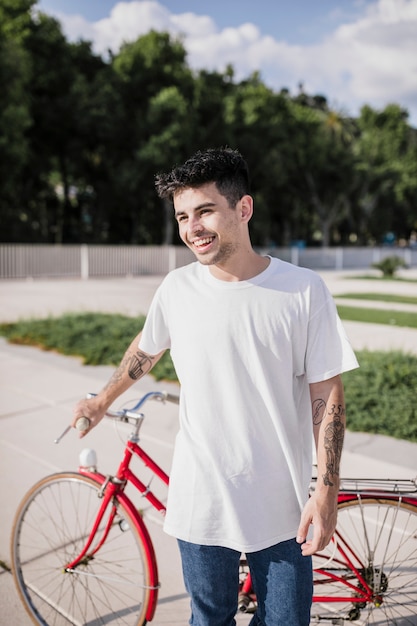 Happy male cyclist standing with his bicycle