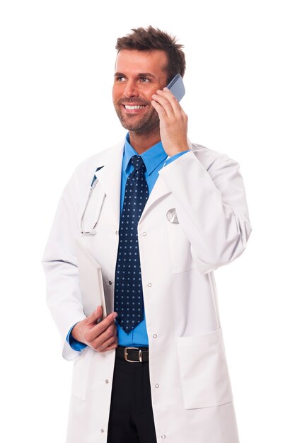 Happy male doctor talking on mobile phone