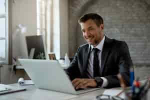 Free photo happy male entrepreneur working on a computer in the office