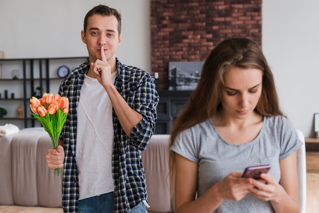 Happy male with bouquet in hand hushing