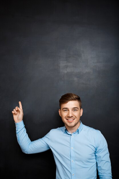 happy man over blackboard point with a finger