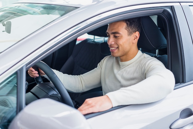 Happy man in car dealership