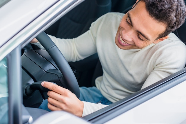 Happy man in car dealership