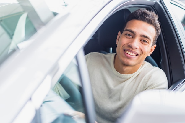 Happy man in car dealership