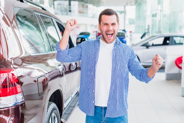 Happy man in car dealership