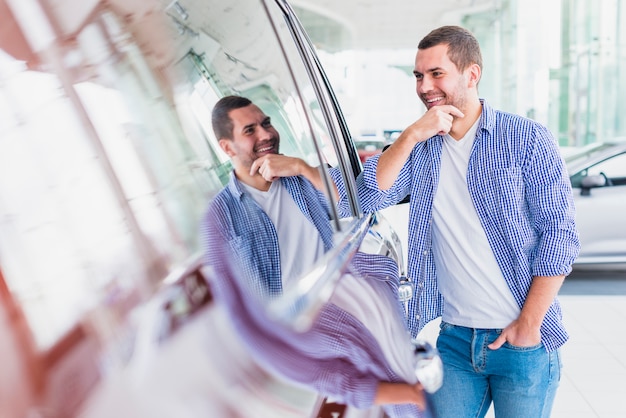 Free photo happy man in car dealership