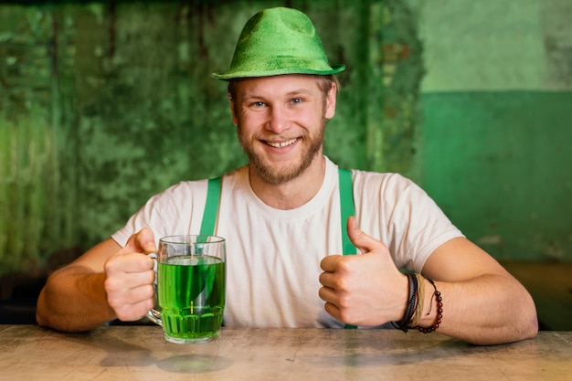 Foto gratuita uomo felice che celebra st. patrick's day con drink