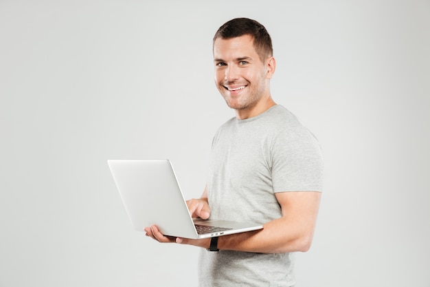 Happy man chatting by laptop computer.