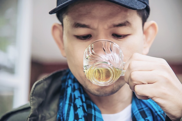 Tazza di tè calda della bevanda felice dell'uomo - la gente asiatica con la bevanda calda del tè si rilassa il concetto