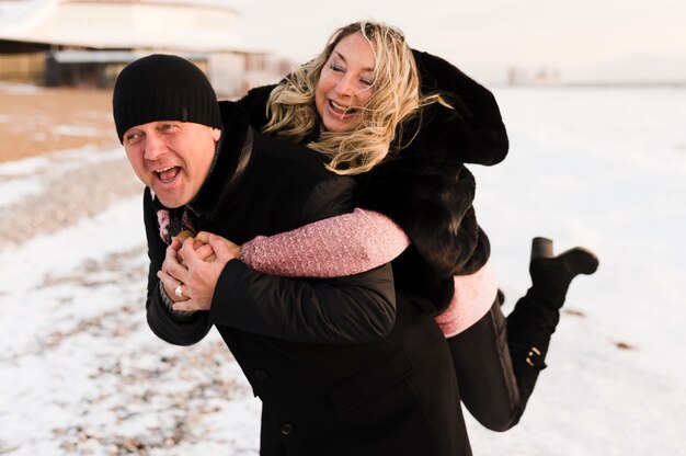 Happy man giving piggyback to wife