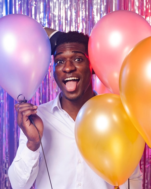 Happy man holding balloons front view