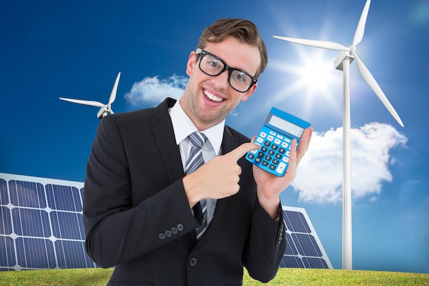 Happy man holding a calculator and a solar panel background