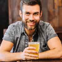 Free photo happy man holding glass of beer