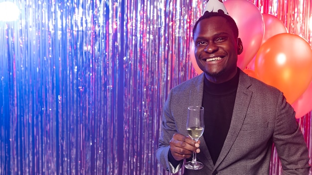 Happy man holding glass of champagne copy space