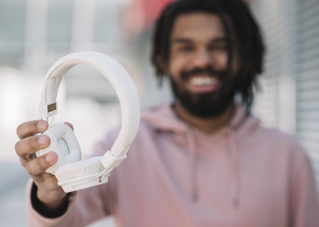 Happy man holding headphones close up