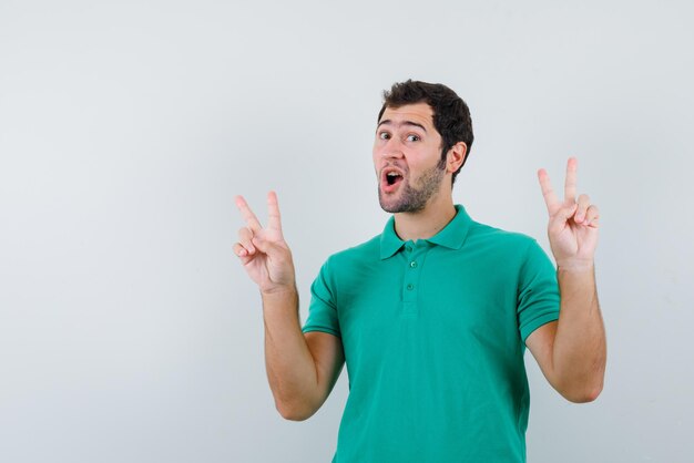The happy man is showing victory gestures on white background