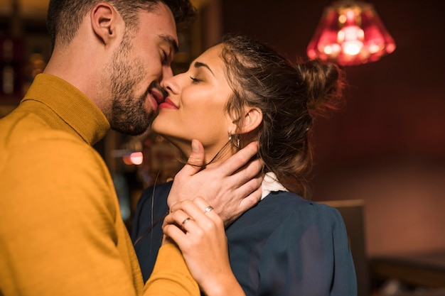 Free photo happy man kissing cheerful woman