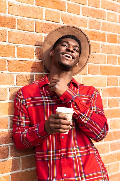 Happy man leaning on a brick wall