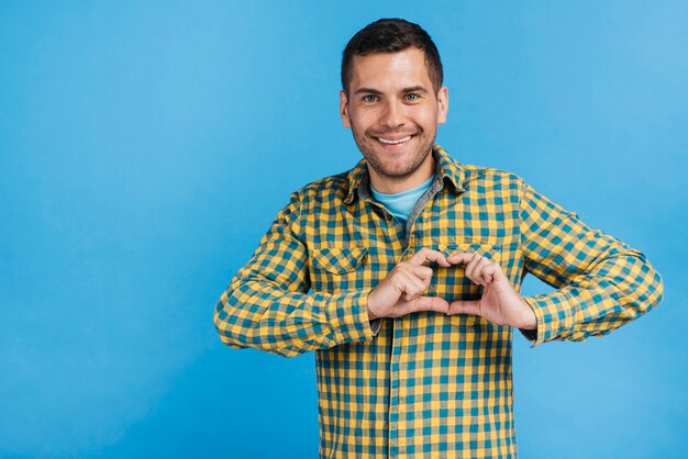 Happy man making a heart with his fingers 